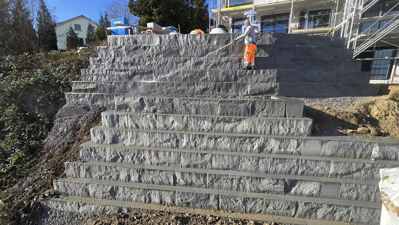 Terrassierte Blocksteinmauer zur Sicherung eines Steilhangs in Wollerau – Soni Gartenbau