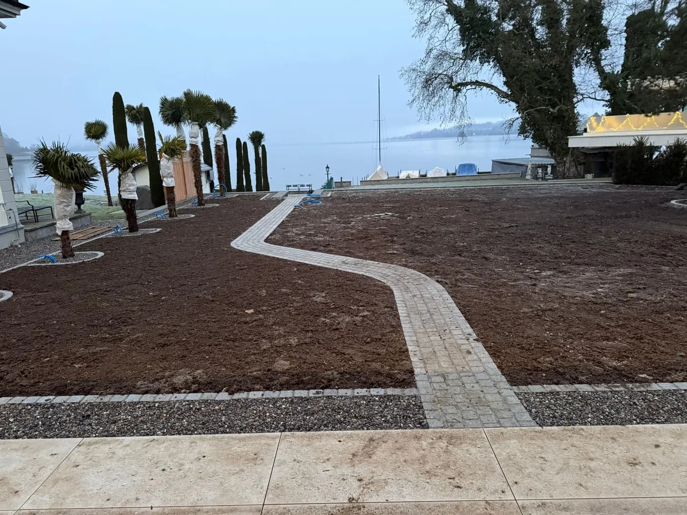 Geschwungener Pflasterweg in einer neu angelegten Gartenanlage am Seeufer in Rapperswil – Soni Gartenbau