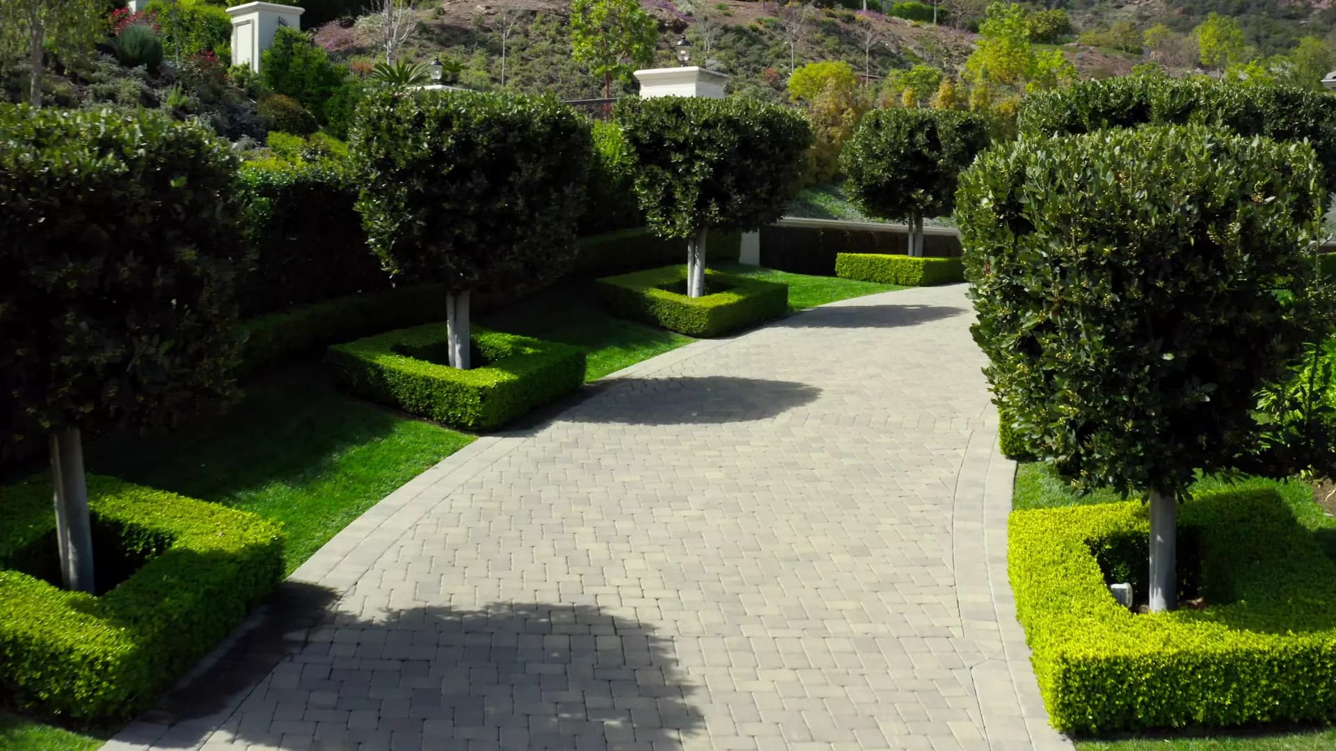 Gepflegte Gartenanlage mit Natursteinpflaesterung, Formschnitt und Rasenflaechen – Gartenbau von Soni Gartenbau in Einsiedeln und der Region Zuerichsee